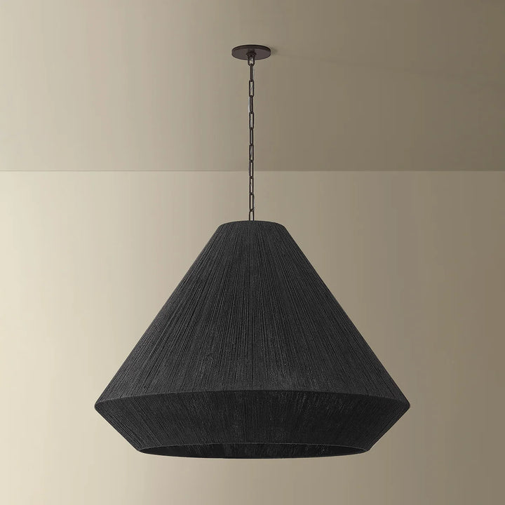 Black pendant lamp hanging against a beige wall