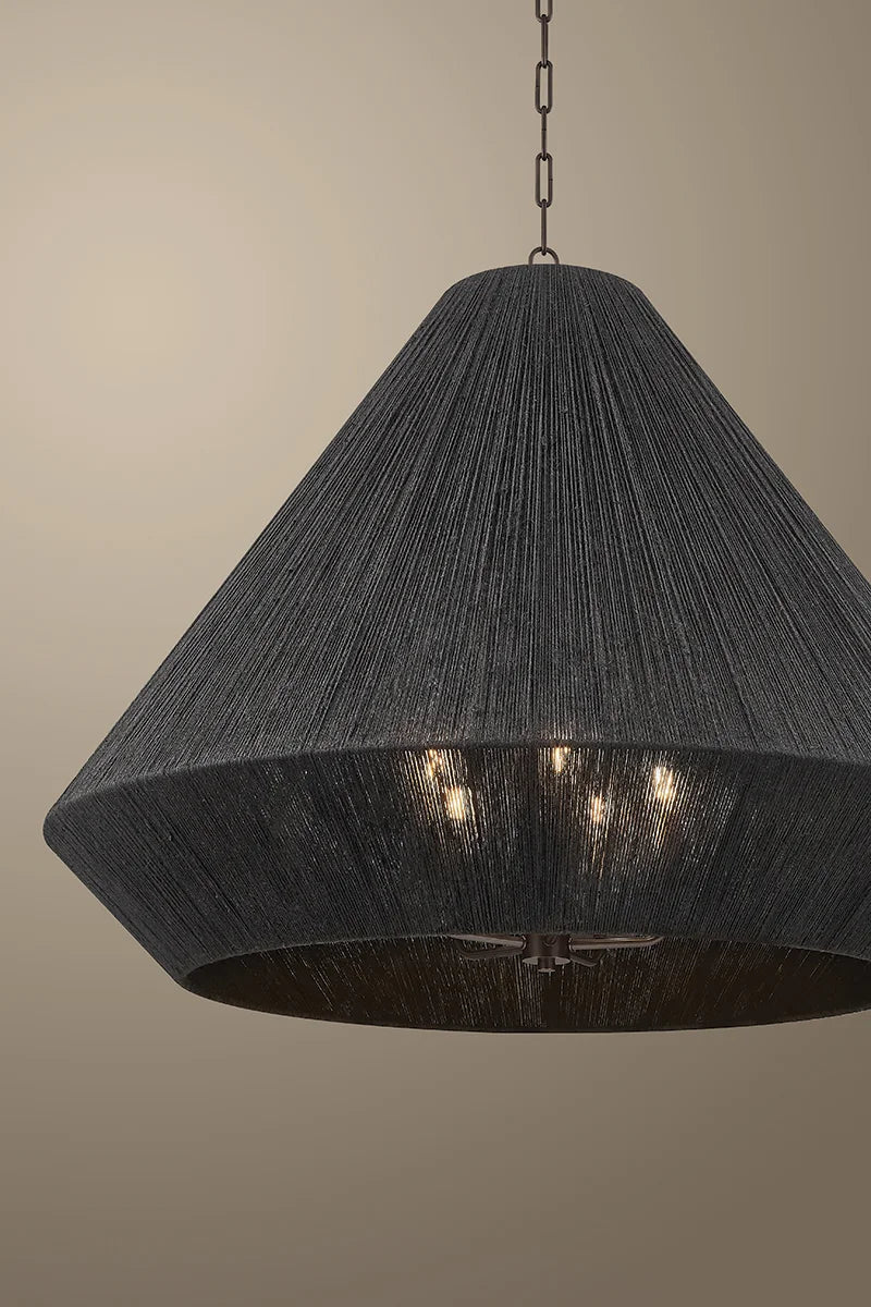 Dark gray pendant light with a textured surface on a beige background