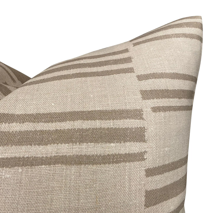 Close-up of a beige pillow with brown stripes on a white background