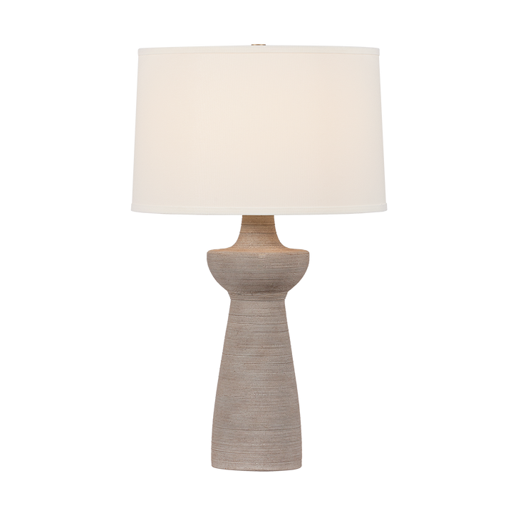 Table lamp with a beige base and white shade on a white background
