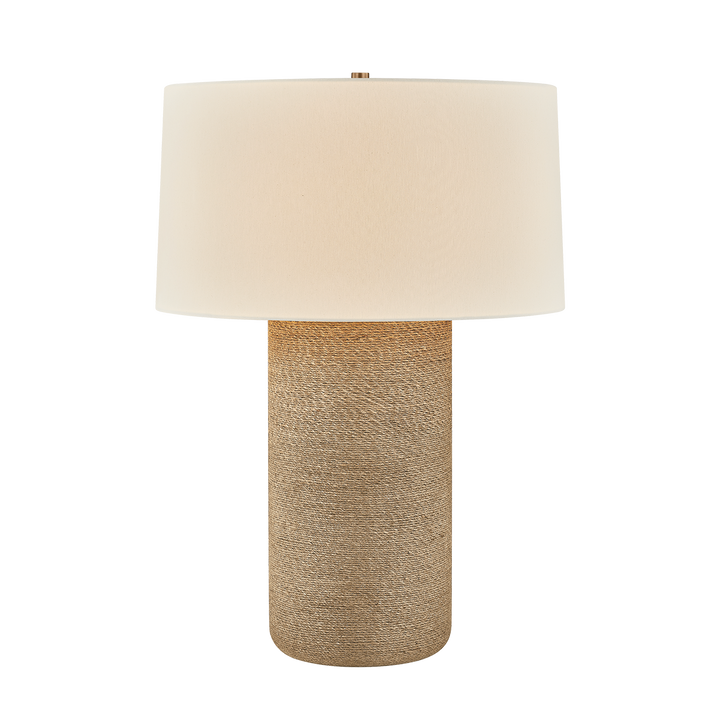 Table lamp with a beige fabric shade and textured brown base on a white background