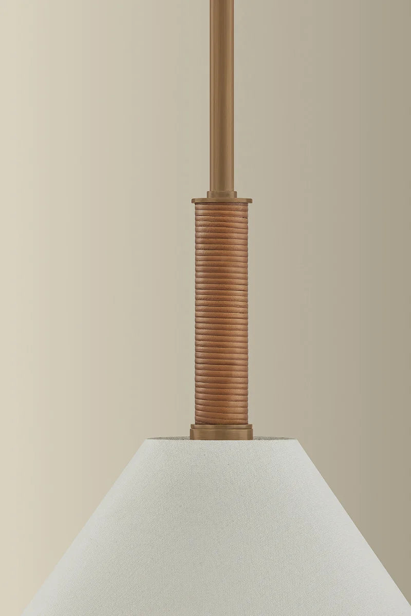 Close-up of a lamp with a textured brown neck and white shade against a beige background